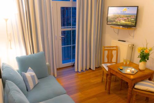 a living room with a blue couch and a table at Levanto in Westermarkelsdorf