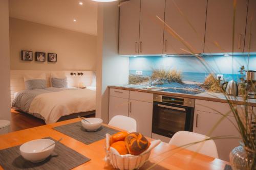 a room with a bed and a table with a kitchen at Sahel in Westermarkelsdorf