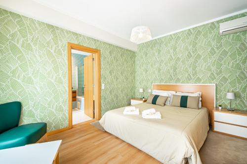 Un dormitorio con una cama y una pared verde. en BeGuest Olhão Ria Formosa View, en Olhão