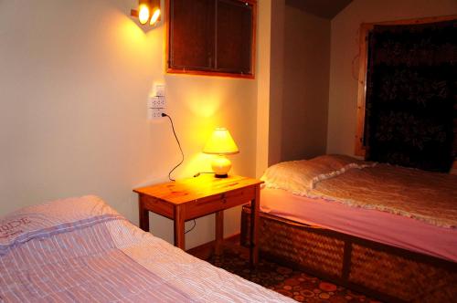 a lamp on a table in a room with two beds at Lazy Hut in Ko Phayam