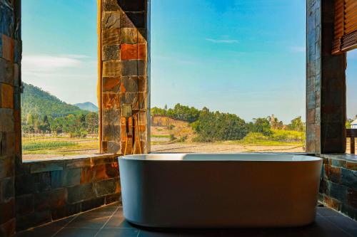 a large bath tub in a room with a window at Diều Sóc Sơn in Sóc Sơn