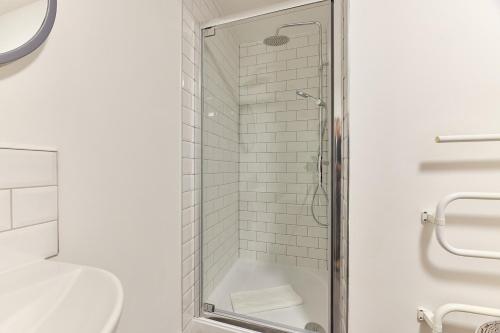a white bathroom with a shower and a toilet at Druridge - Properties Unique in North Shields