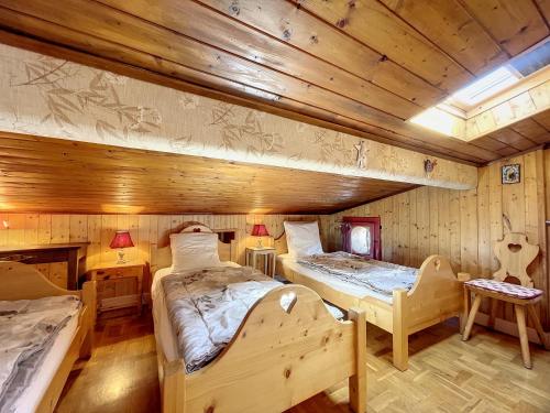deux lits dans une chambre aux murs en bois dans l'établissement Clos 24 - appartement - 5 pers - proche centre, aux Gets