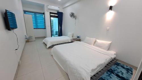 a bedroom with two beds and a tv in it at HT Airport Inn in Phù Xá Ðoài