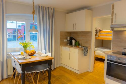 una cucina con tavolo e una piccola cucina con letto di Mistral a Westermarkelsdorf