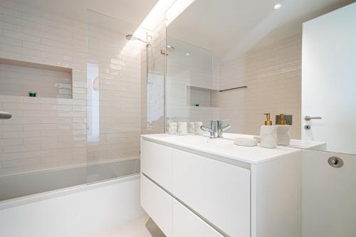 um banheiro branco com uma pia e um chuveiro em BeGuest Only Good Vibes - Cabanas em Tavira