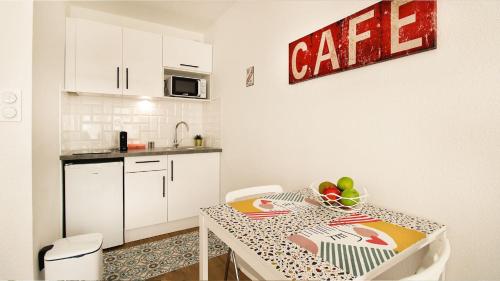 - une petite cuisine avec une table et un bol de fruits dans l'établissement HOMEY PURITY / NEW / Parking gratuit / Proche Tram / Aux portes de Genève, à Ambilly