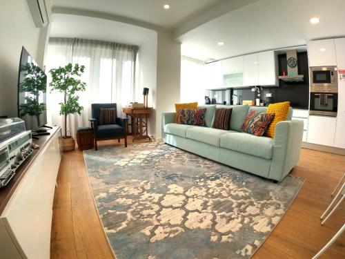 a living room with a couch and a kitchen at Lisboa T3 moderno Benfica in Lisbon