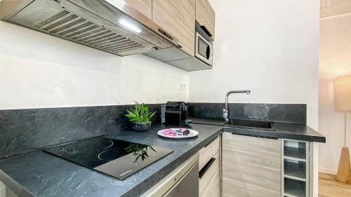 a kitchen with a counter top with a sink at HOMEY TITI - Hyper-centre - Proche Gare et Tram - Lit Convertible - Wifi gratuit in Annemasse