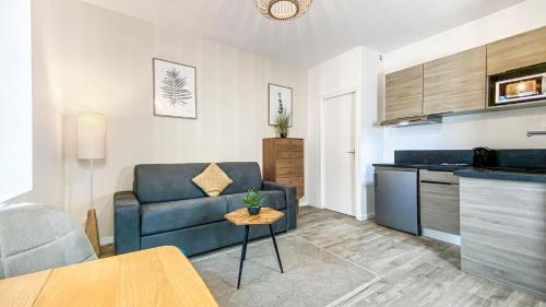 a living room with a couch and a table at HOMEY TITI - Hyper-centre - Proche Gare et Tram - Lit Convertible - Wifi gratuit in Annemasse
