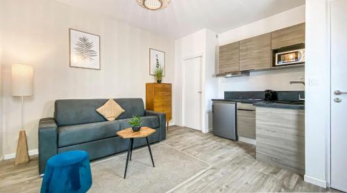 a living room with a couch and a table at HOMEY TITI - Hyper-centre - Proche Gare et Tram - Lit Convertible - Wifi gratuit in Annemasse