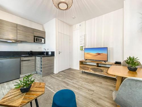 a kitchen with a table and a tv in a room at HOMEY TITI - Hyper-centre - Proche Gare et Tram - Lit Convertible - Wifi gratuit in Annemasse