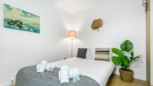 une chambre avec un lit et une plante en pot dans l'établissement Homey AWAY - Centre-ville / Au Calme / Proche des transports pour Genève, à Annemasse