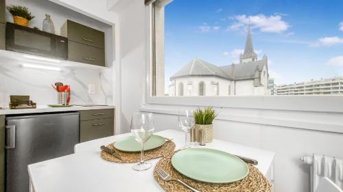 une cuisine avec une table avec deux verres et une fenêtre dans l'établissement Homey AWAY - Centre-ville / Au Calme / Proche des transports pour Genève, à Annemasse