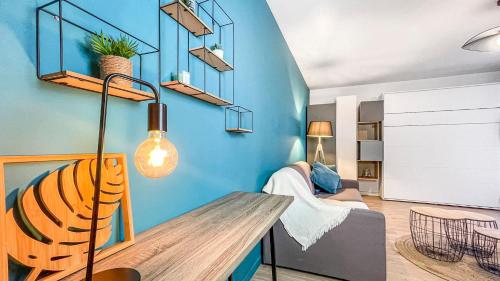- un salon avec un mur bleu et un canapé dans l'établissement HOMEY HELSINKI - Hyper centre - Proche Genève - Terrasse privée - Wifi & Netflix, à Annemasse