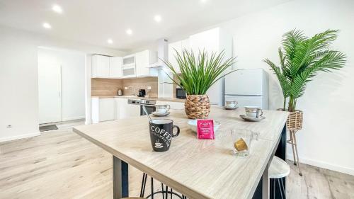 a kitchen with a wooden table with plants on it at HOMEY SAKINE- Proche centre- Netflix- Wifi in Cluses