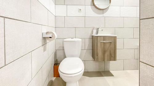 a white bathroom with a toilet and a mirror at HOMEY SAKINE- Proche centre- Netflix- Wifi in Cluses