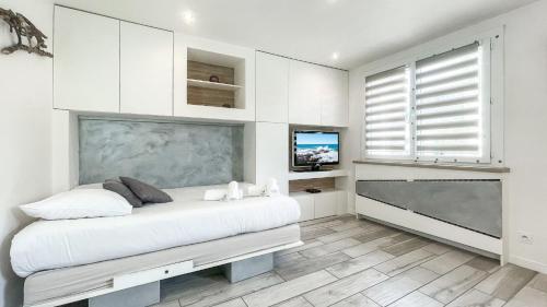 une chambre blanche avec un lit et une grande fenêtre dans l'établissement HOMEY TIDY - NEW / Proche Centre Annecy / Parking gratuit / Logement entièrement équipé, à Annecy