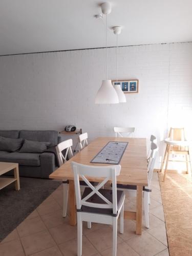 a living room with a wooden table and chairs at Bungalow 2702 in Tossens in Tossenserdeich