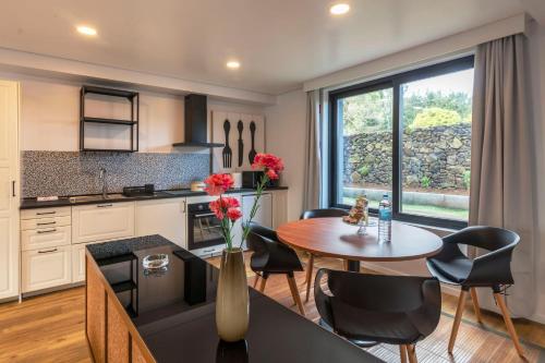 a kitchen with a table and chairs and a window at Your Azorean Home RRAL 3378 in Ribeira Grande