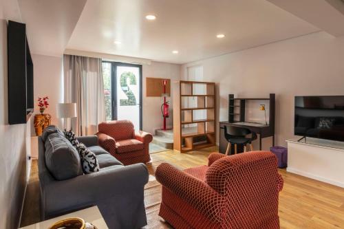a living room with two couches and a piano at Your Azorean Home RRAL 3378 in Ribeira Grande