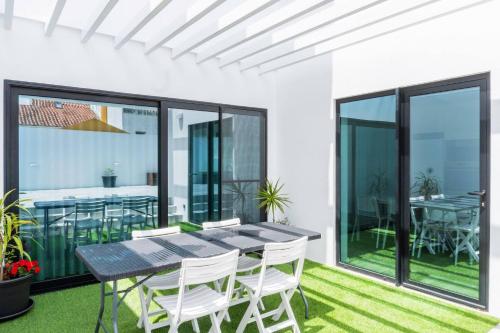 a dining room with a table and chairs on a balcony at EnCanto Terrace House in Ponta Delgada