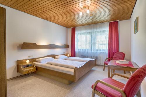 a bedroom with a bed and a table and chairs at Drei Tannen - Wohnung 06 - Apartmenthaus, Titisee, nahe Badeparadies in Titisee-Neustadt