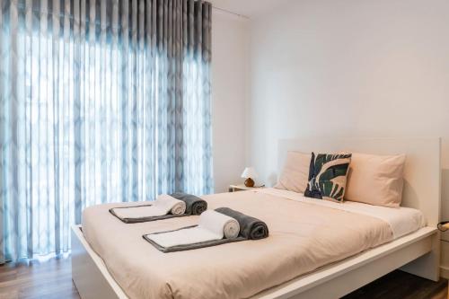 a bedroom with a large bed with towels on it at EnCanto Terrace House in Ponta Delgada