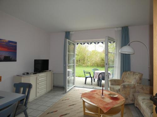 un salon avec un canapé et une table dans l'établissement To Hus, Reihenhaus 6, à Kellenhusen