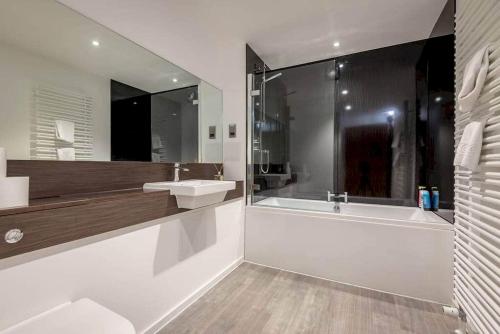 a bathroom with a tub and a sink and a shower at Square Green - No 12 Garden in St. Andrews