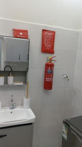 a kitchen with a sink and a fire extinguisher on the wall at مرفق الشلال السياحي in Jeddah