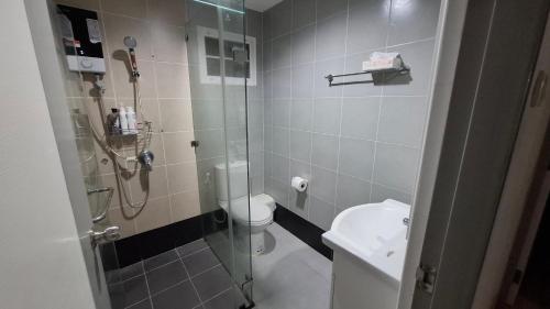 a bathroom with a toilet and a glass shower at A,B house Chiangmai in Chiang Mai