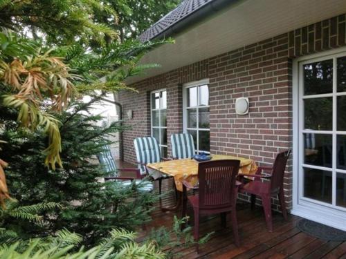 a patio with a table and chairs on a deck at Zum Hasenlager HA14 in Sögel