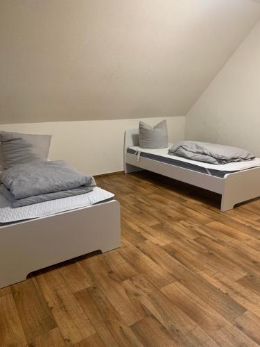 Dos camas en una habitación con suelo de madera. en Pool & Peace, en Güstrow