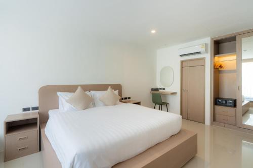 a bedroom with a large white bed and a desk at Sunnyside Kata in Kata Beach