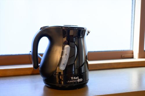 a black tea kettle sitting on a table at 玉造和暖 WaDan 島根県玉造温泉街に佇む和の趣あふれる古民家旅館 supported by COCOSTAY in Matsue