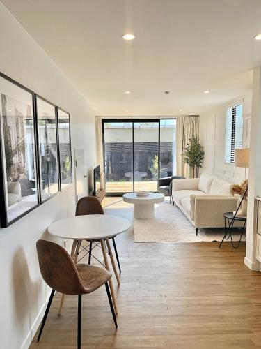 a living room with a couch and a table and chairs at New build City Townhouse & Gated Car Park in Christchurch