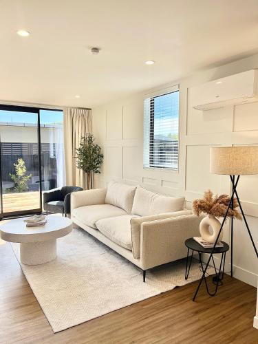 a living room with a couch and a table at New build City Townhouse & Gated Car Park in Christchurch