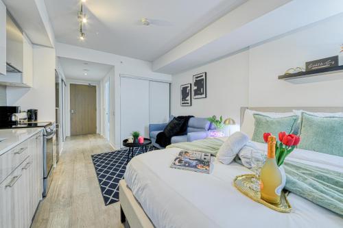 a bedroom with a large bed and a kitchen at RivetStays - The Jarvis in Toronto