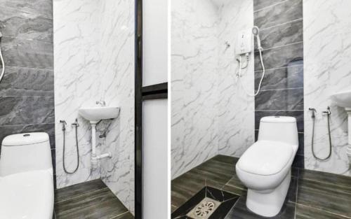 a bathroom with a toilet and a shower stall at TH Hotel in Bahau