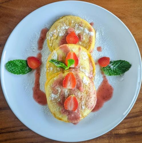 due pancake con fragole su un piatto di pane di The Prana Suite ad Ubud
