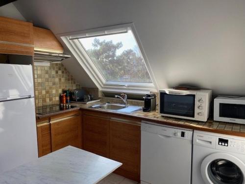 une petite cuisine avec un évier et une fenêtre dans l'établissement Appart T2 Mezzanine au cœur de La Baule - FR-1-392-243, à La Baule