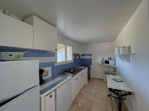 - une petite cuisine avec des placards blancs et du carrelage bleu dans l'établissement Cabane de Gardian 6 pers, nature, animaux admis, parking - FR-1-475-186, à Saintes-Maries-de-la-Mer