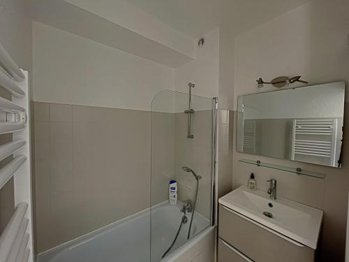 une salle de bain blanche avec une douche et un lavabo dans l'établissement Appartement 4 personnes avec climatisation et parking aux Saintes-Maries-de-la-Mer - FR-1-475-182, à Saintes-Maries-de-la-Mer