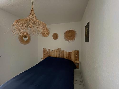 - une chambre avec un lit bleu et un lustre dans l'établissement Appartement 4 personnes avec climatisation et parking aux Saintes-Maries-de-la-Mer - FR-1-475-182, à Saintes-Maries-de-la-Mer