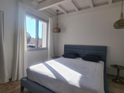 sypialnia z niebieskim łóżkiem i oknem w obiekcie Maison neuve élégante pour 6 pers. avec climatisation, proche du centre de Saintes-Maries-de-la-Mer - FR-1-475-187 w Saintes-Maries-de-la-Mer