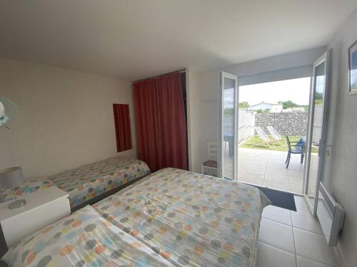 une chambre d'hôtel avec un lit et un balcon dans l'établissement T2 2* avec Terrasse & Jardinet - 400m Plage - FR-1-738-45, à Saint-Palais-sur-Mer