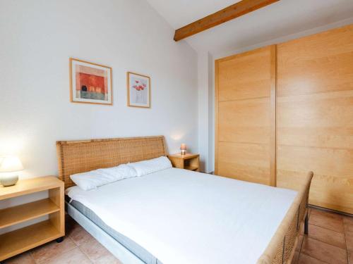 - une chambre avec un lit et un placard en bois dans l'établissement Villa 3 pièces à Narbonne-Plage, animaux acceptés - FR-1-409-276, à Narbonne