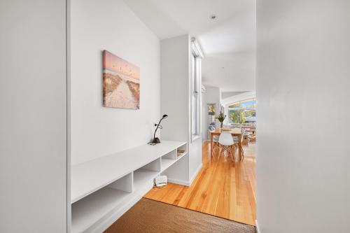 a living room with white walls and a white desk at Jan Juc Beach Home in Torquay