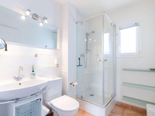 une salle de bain blanche avec une douche et un lavabo dans l'établissement Villa 3 pièces à Narbonne-Plage, animaux acceptés - FR-1-409-276, à Narbonne